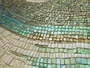 Close up of abstract mosaic wall art with taupe, grey, brown and light blue colors in textured wave pattern