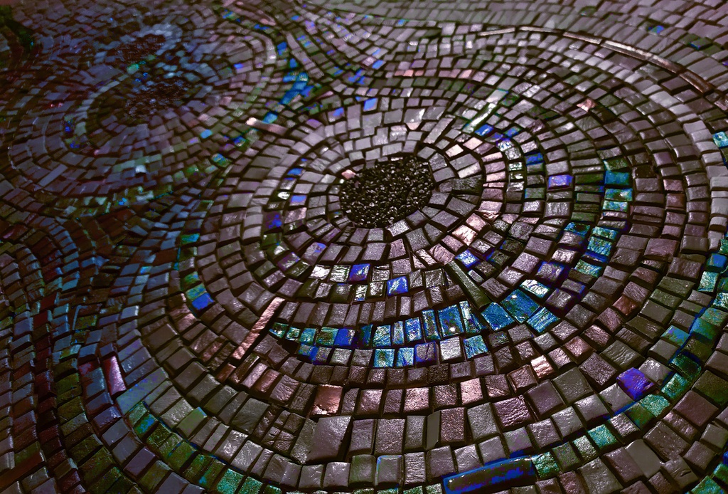 Detail of mosaic art with concentric circles in iridescent indigo, peacock blue, and sapphire shades